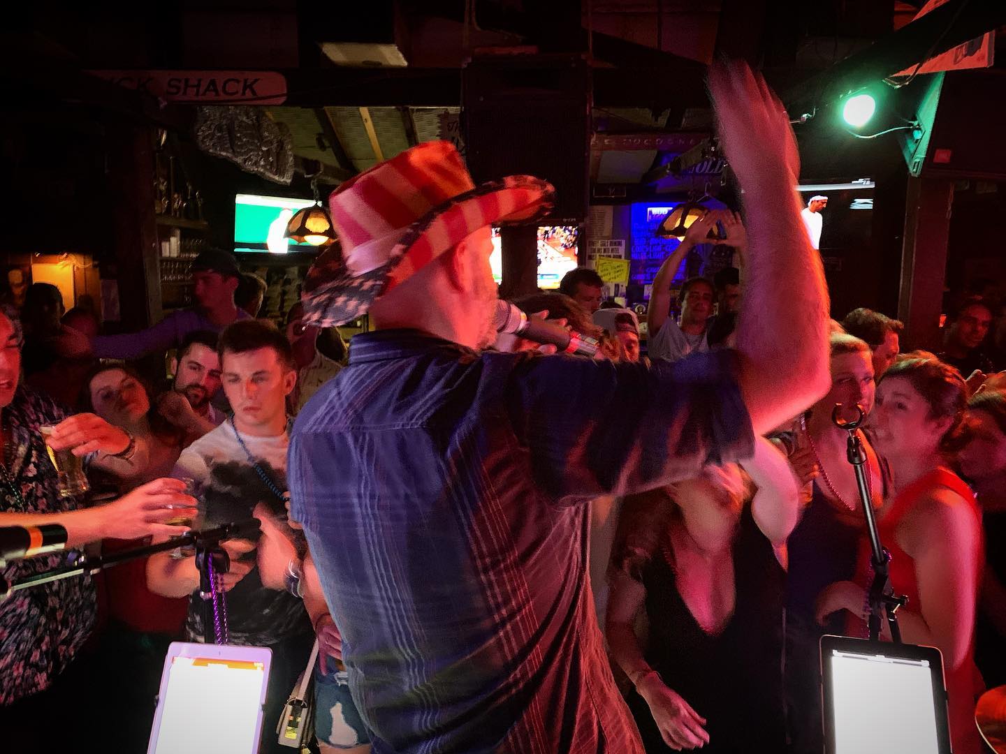 Man in cowboy hat on stage in front of a crowded audience